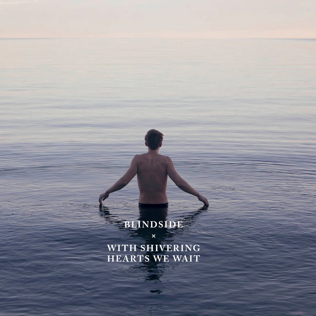 Album Art of Blindside's With Shivering Hearts We Wait album - On a very calm lake or ocean that stretches to the horizon, a young man is standing shirtless in the water up to his waist, and his hands are outstretched on each side just so that his fingers are touching the top of she water. He's looking away from the camera towards the never-ending water and the horizon, which has ha bit of a pink hue to it like it is magic hour. Printed in the bottom middle is the band's name in white text, followed by a small 'x' and then the album title in the same font.