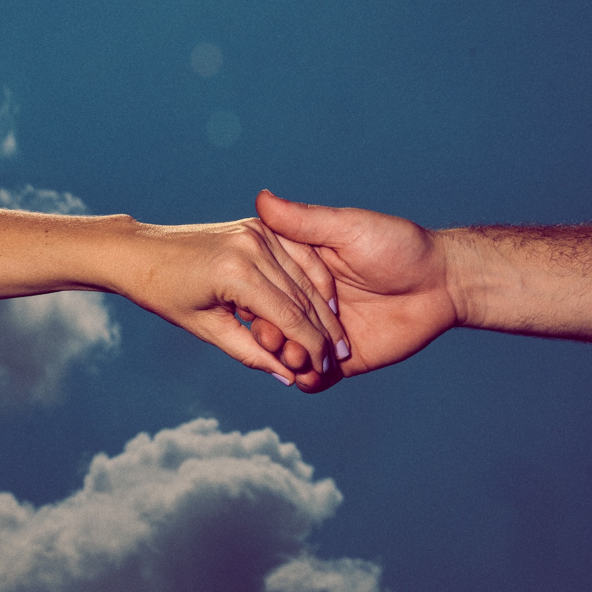 Album Art of Colony House's 77 (Pt. 2) album - In front of a blue, partly cloudy backdrop, tho hands are coming from opposite sides and are clasped together. From the left is a more petite hand and a bit of the forearm with light pink nail polish. From the right is a bigger hand and more burly forearm.