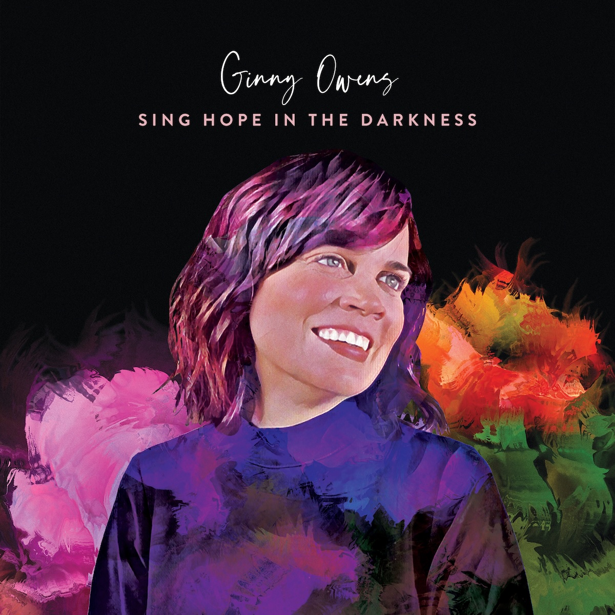 Album Art of Ginny Owens's Sing Hope In The Darkness EP - A photo of a middle-aged white woman with brown hair on a black background, or maybe it's a painting based off a photo or an effect painted on top of a photo, because her face looks pretty photo-realistic, but the rest looks like a colorful painting. Her hair looks like a mix of purple and brown strokes, and her shirt looks like it's painted over with muted, dark colors. Behind her shoulders are bright colors, pink on her left and orange and a darker green on her right; it looks like mixes of colored paint with sloppy brushstrokes.
