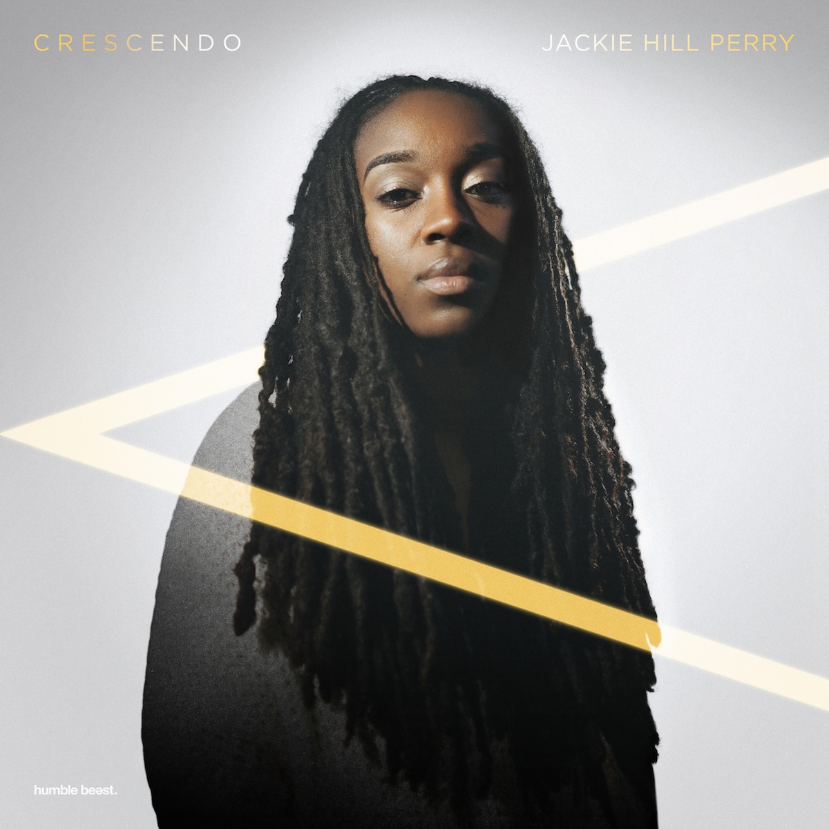 Album Art of Jackie Hill Perry's Crescendo album - On a white background which is a bit more grey at the edges, there's a color photo of a black woman with long, braided hair looking into the camera while holding her chin high. From left to right, there is the musical symbol '<', which is a crescendo. It means the music starts quiet and gets progressively louder. The top part of the '<' passes behind the artist, but the bottom part is in front of her. The front part looks more gold and the back part looks a bit more white. In the top left is printed the album title, and in the top right the artist name, as well in the bottom left in small print is the label name, 'humble beast'.