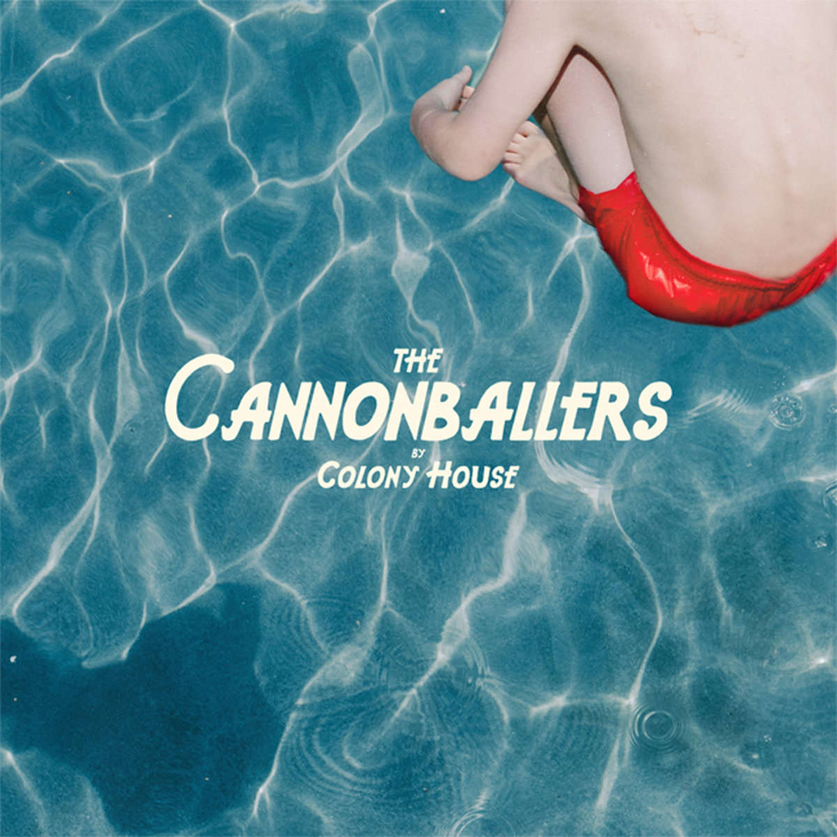 Album Art of Colony House's The Cannonballers album - A photo of a pool from above, with an aqua blue hue and parts of it are whiter than others from the light bending through the water. In the top right, above the water is the torso and arms and legs of a white kid in red swim trunks, with his legs tucked under his chest. In the bottom left, you can see his shadow on the water.</body></html>
