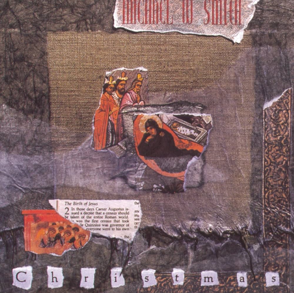 Album Art of Michael W. Smith's Christmas album - It looks like paper artwork, with a base background of a gray forest branches, and a printout of a gold frame in the bottom and right halfway up, and the look of a burlap cloth in the middle. In the middle, a few torn-out reproductions of sacred art with three kings, a stable and Mary with a baby in a manger on three separate pieces of paper layered on top of each other. To the bottom left, a bit of the biblical passage of the birth of Jesus from a bible is torn out and placed there. At the top, a white piece of paper with the artist name and at the bottom, individual letters spelling 'Christmas', each on their own bit of paper.