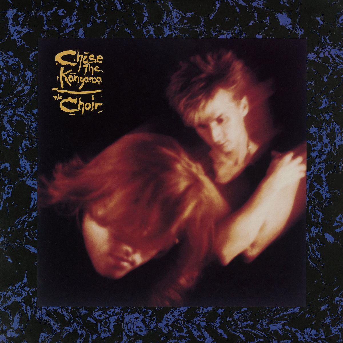 Album Art of The Choir's Chase The Kangaroo album - A thick border of black with blue drawings making an indecipherable pattern surrounds the main photo. The main photo is one man on the left leaning in towards the camera and his hair is in front of his eyes. The second person is off to the right further away, and is holding his own shoulders and lookng down. Both people are slightly blurry like they were photographed in motion.</body></html>