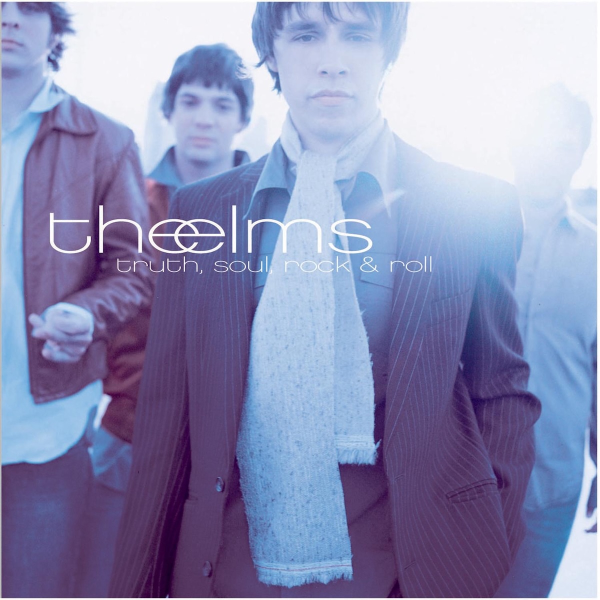 Album Art of The Elms's Truth, Soul, Rock And Roll album - A photo of four young men in collared shirts and coats. The one in the front has a pinstriped suit coat and a scarf. The man on the right's head is almost completely obscured by a bright light and is behind the one in the front, so not too much detail to make out of them there. They are all sporting short hair and their outfits all seem to have versions of dark red or blue colors.</body></html>