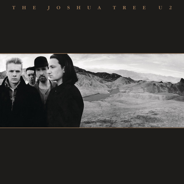 Album Art of U2's The Joshua Tree album - The majority is a black background on the top and bottom. At the very top, the album title and band name are printed in small, gold letters. In the middle third, surrounded by a gold line at the top and bottom, is a black and white photo of four men. The left 3 are looking a the camera, and the fourth is looking of to the left. They're all wearing dark jackets, and the third one has a dark bowler hat.</body></html>
