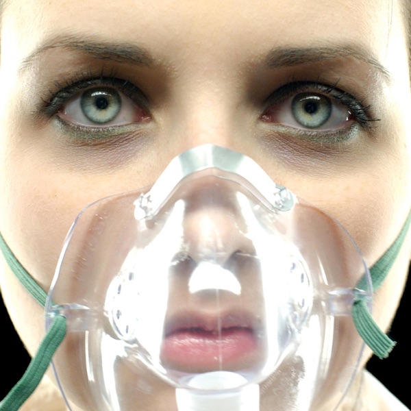 Album Art of Underoath's They're Only Chasing Safety album - A close up photo of a woman's face, it looks like in front of a black background. There are no hairs in front of her face, and it's so close we cannot really see her scalp. The lighting is very bright and sterile from the front, though her eyes are in shadow a bit. Her mouth and nose are covered by a clear plastic mask held on her head by aqua green elastic straps going behind her head on both sides.</body></html>